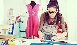 White woman fashion designer making clothing patterns